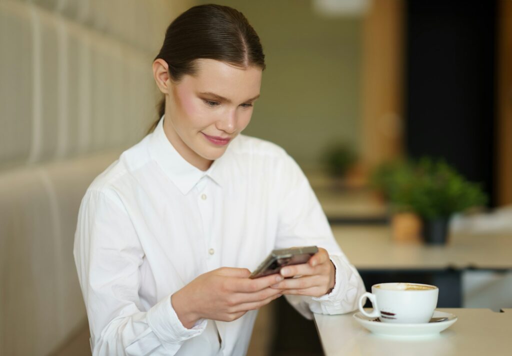 Beauty businesswoman using phone in a chic cafeteria